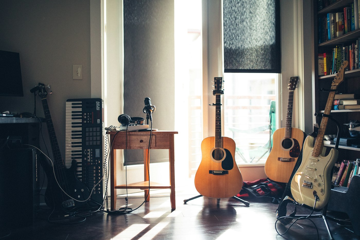 A weathered wooden stage with scattered equipment, sunlight streaming through a cracked ceiling, empty chairs in front, and a faint outline of a leaking pipe overhead.